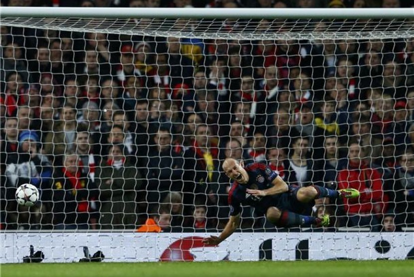 Winger Bayern Muenchen, Arjen Robben, berteriak kesakita saat dilanggar kiper Arsenal, Wojciech Szczesny (tidak terlihat), dalam leg pertama babak 16 besar Liga Champions di Stadion Emirates, London, Rabu (19/2). 