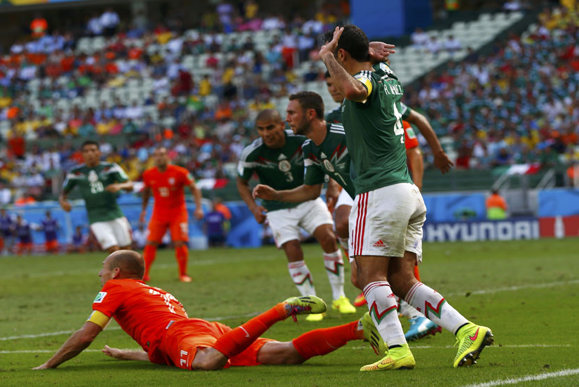 Winger Belanda, Arjen Robben (kiri), dilanggar di kotak penalti saat menghadapi Meksiko di laga babak 16 besar Piala Dunia 2014 Brasil di Arena Castelao, Fortaleza, Ahad (29/6). 