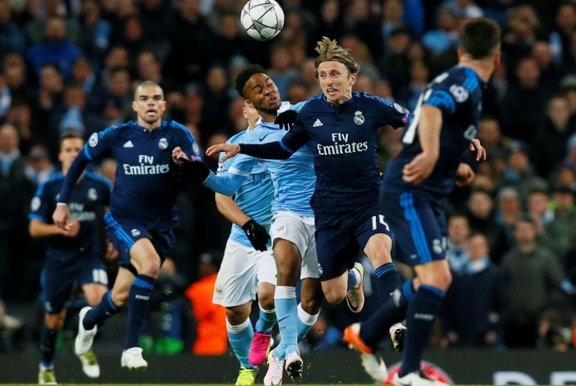 Winger Manchester City Raheem Sterling (biru langit) berduel bola dengan gelandang Real Madrid Luca Modric.