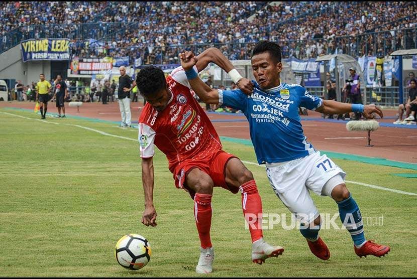 Winger Persib Gozali Siregar (kanan) berebut bola dengan pesepak bola Arema FC Alfin Tuasalamony (kiri) saat laga lanjutan Liga 1 di Stadion Gelora Bandung Lautan Api, Bandung, Jawa Barat, Kamis (13/9).