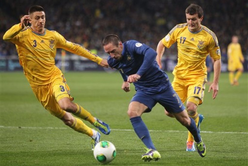 Winger Prancis Franck Ribery (kanan) dengan susah payah meloloskan diri dari hadangan para pemain Ukraina di laga playoff Piala Dunia 2014.