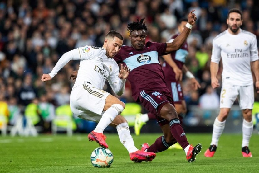 Winger Real Madrid Eden Hazard (kiri) menggocek bola ditempel oleh bek Celta Vigo Joseph Aidoo. Madrid ditahan imbang Celta 2-2.