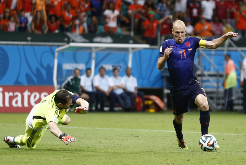 Winger Timnas Belanda, Arjen Robben (kanan), mengecoh kiper Iker Casillas menjebol gawang Spanyol dalam laga Grup B Piala Dunia 2014 di Arena Fonte Nova, Salvador, Jumat (13/6). 