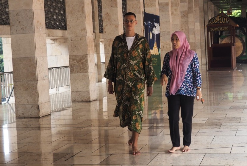 Kunjungan Wisman Masjid Istiqlal: Wisatawan asal Inggris Rachim (kiri) berjalan sambil mendengarkan penjelasan pengurus saat berkunjung ke Masjid Istiqlal, Jakarta Pusat, Selasa (26/2/2019). 