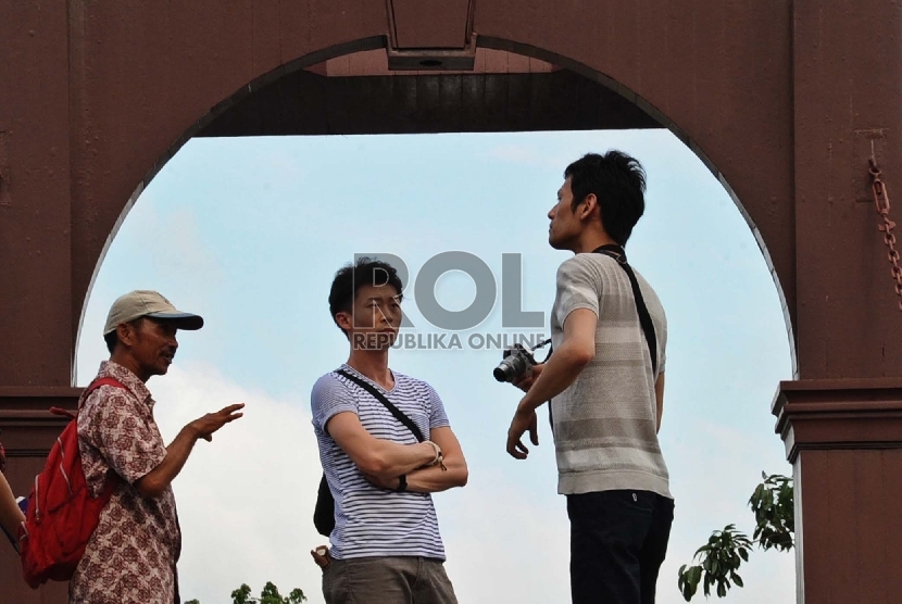  Wisatawan asing mendengarkan penjelasan pemandu wisata di kawasan Kota Tua, Jakarta, Ahad (10/1). (Republika/Tahta Aidilla)