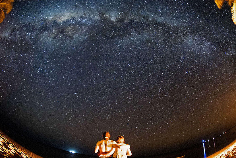 Wisatawan asing menikmati pemandangan gugusan Bimasakti atau Milky Way yang terlihat membujur di langit selatan pulau Rote Ndao, Nusa Tenggara Timur, Ahad (16/8).    (Antara/M Agung Rajasa)