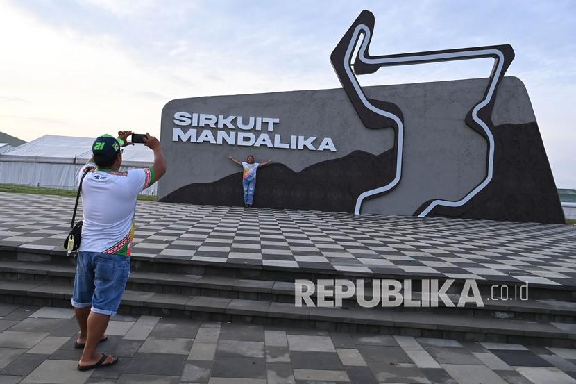 Wisatawan berfoto di depan tulisan dan lambang sirkuit Mandalika di kompleks Pertamina Mandalika International Street Circuit, Lombok Tengah, NTB, Senin (21/3/2022). 