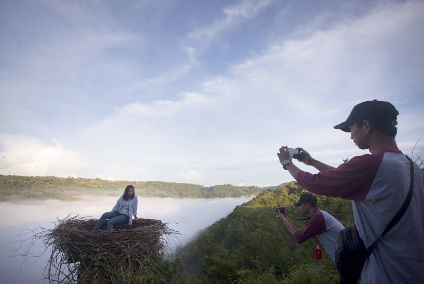 Wisatawan berfoto di kawasan wisata Bukit Mojo, Gumelem, Dlingo, Bantul, DI Yogyakarta, Minggu (2/4). 