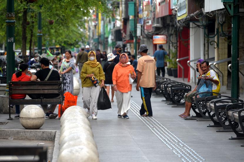 Wisatawan berjalan-jalan tanpa menggunakan masker di kawasan wisata Malioboro, Yogyakarta.