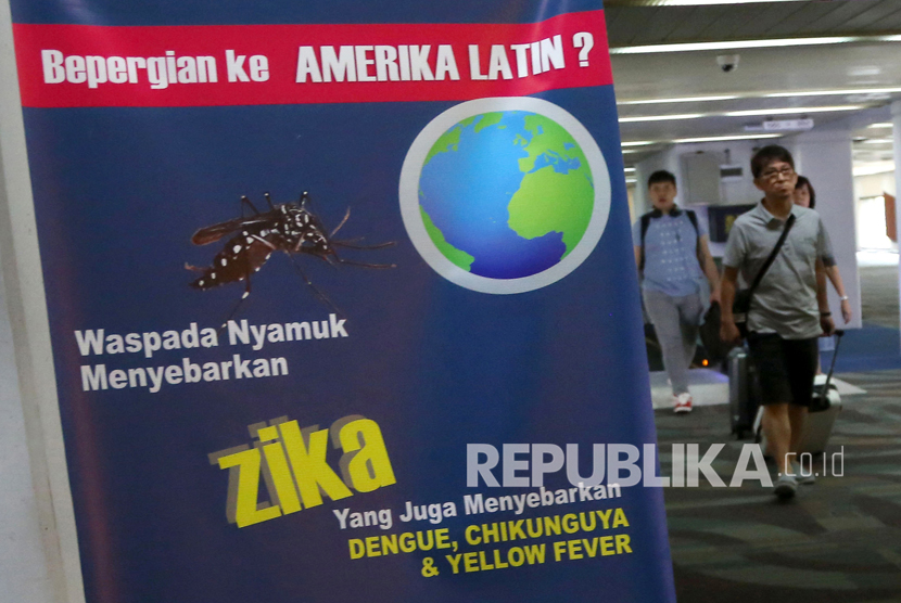 wisatawan  berjalan melewati sebuah banner himbauan kewaspadaan terhadap virus Zika di Bandara Internasional Soekarno-Hatta di Tangerang, Jumat, (2/9). 