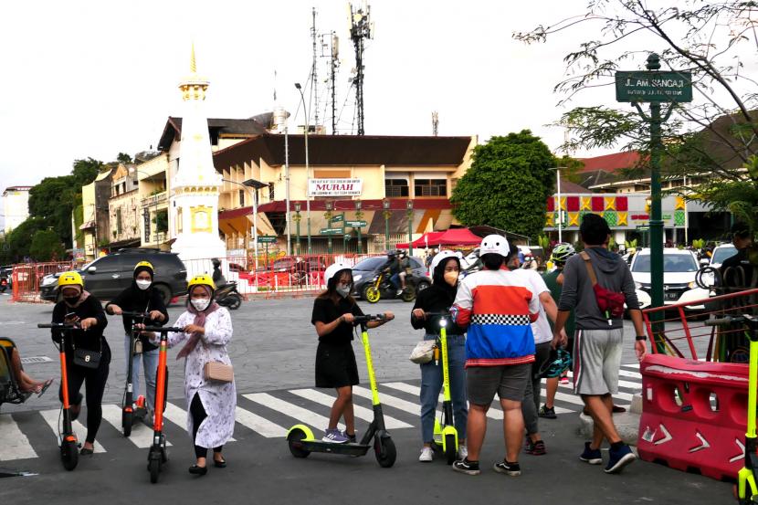 Wisatawan berkeliling dengan skuter listrik di kawasan Tugu Pal Putih, Yogyakarta.