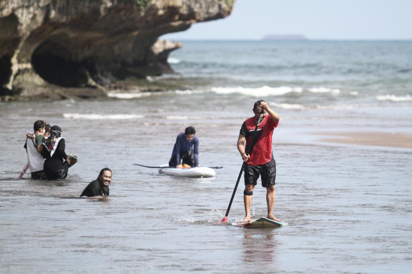 Gunung Kidul Perketat Jalur Alternatif Menuju Objek Wisata. Wisatawan bermain air di kawasan Pantai Baron, Tanjungsari, Gunungkidul, DI Yogyakarta, Senin (7/6/2021). Destinasi wisata yang menawarkan pemandangan pantai dan kuliner makanan laut tersebut masih menjadi destinasi andalan di Gunungkidul. 