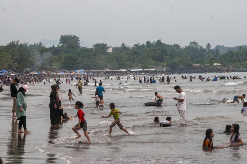 Wisatawan bermain air di Pantai Anyer, Kabupaten Serang, Banten. Polres Cilegon mengantisipasi gangster yang diduga berkumpul di Pantai Anyer.