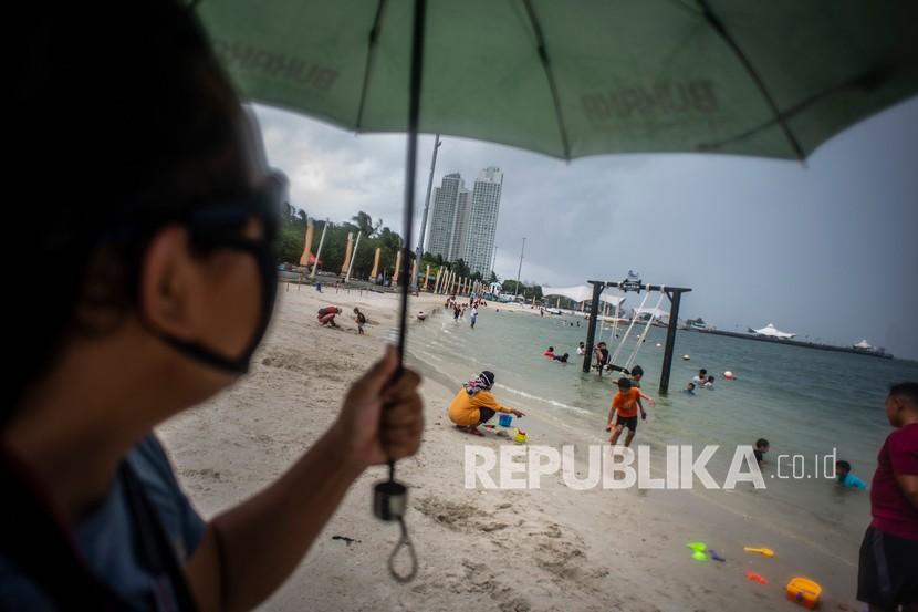 Wisatawan bermain air di Pantai Lagoon, Taman Impian Jaya Ancol, Jakarta, Rabu (9/12). Pada masa libur akhir tahun ini, Ancol menjadi salah satu tempat wisata yang ditutup sementara oleh Pemprov DKI Jakarta. (ilustrasi)