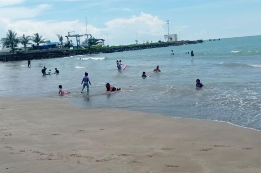 Wisatawan bermain air di pinggir Pantai Ciantir kawasan Sawarna, Kabupaten Lebak, Provinsi Banten, Sabtu (13/4/2024). 