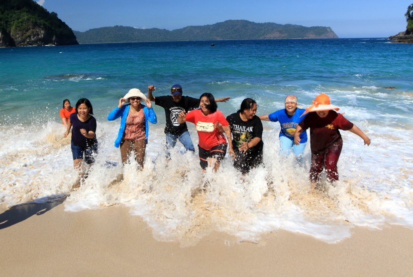Wisatawan bermain di Pantai Teluk Hijau di Banyuwangi, Jawa Timur, Selasa (18/6/2019). 