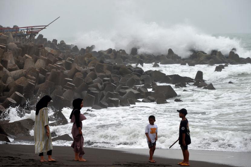 Wisatawan bermain menjauh dari ombak saat gelombang tinggi di Pantai Glagah, Kulonprogo, Yogyakarta.