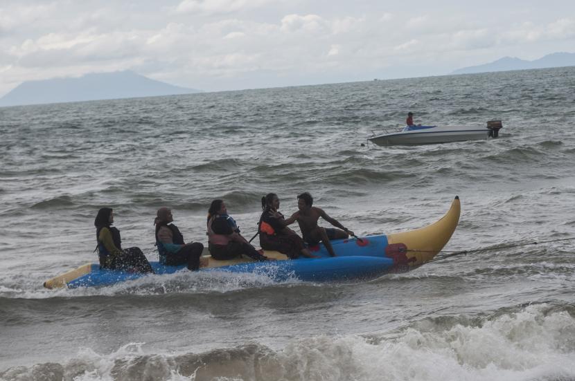 Wisatawan bermain wahana air di Pantai Carita, Pandeglang, Banten. Destinasi wisata permainan air di Lebak, Banten masih dipadati wisatawan.