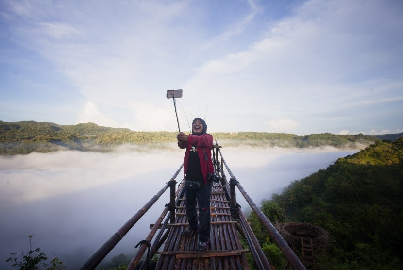 Wisatawan berswafoto di kawasan wisata Bukit Mojo, Gumelem, Dlingo, Bantul, DI Yogyakarta, Minggu (2/4). 