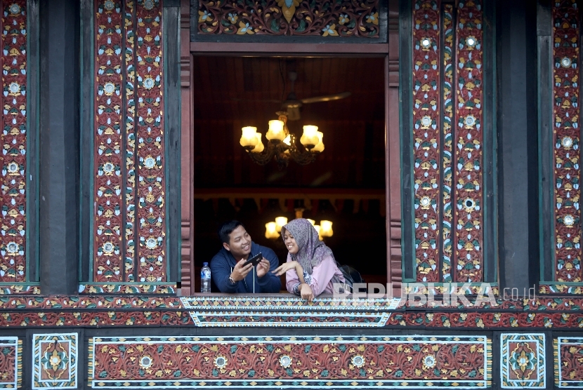  Wisatawan Domestik berekreasi di Anjungan Provinsi Sumatera Barat Taman MIni Indonesia Indah (TMII), Jakarta, Selasa (1/8).