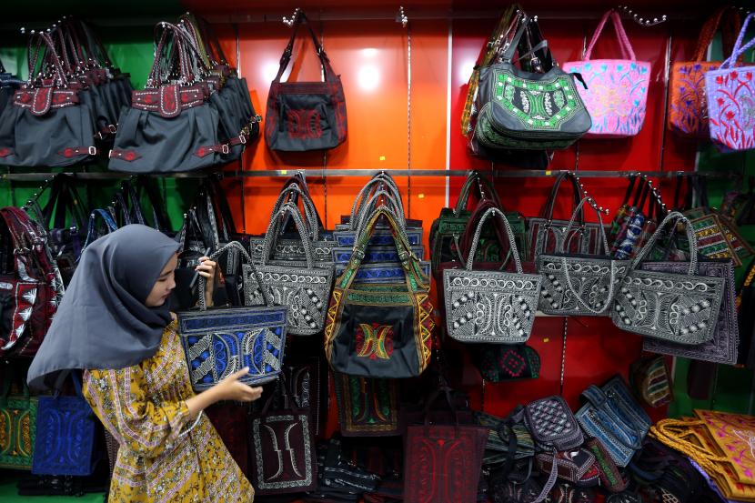 Wisatawan domestik memilih tas motif khas Aceh yaitu produk Usaha Mikro, Kecil dan Menengah (UMKM) yang ditawarkan di pusat oleh-oleh, (ilustrasi). OJK menyarankan pemudik memanfaatkan asuransi pengiriman untuk mengirim oleh-oleh dari kampung halaman.