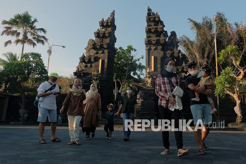 Wisatawan domestik menggunakan masker saat liburan Idul Adha 1441H di masa Adaptasi Kebiasaan Baru tahap II di obyek wisata Tanah Lot, Tabanan, Bali, Sabtu (1/8/2020). Obyek wisata tersebut mulai dikunjungi wisatawan dari luar Pulau Bali dengan menerapkan protokol kesehatan COVID-19 meskipun jumlahnya masih sedikit. 