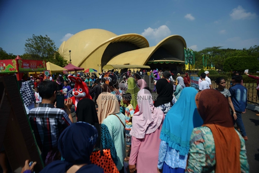 Wisatawan lokal memadati pelataran Teater Keong Emas Taman Mini Indonesia Indah (TMII), Jakarta, Ahad (19/7). Musim libur Lebaran seringkali dijadikan momentum bagi setiap keluarga untuk berkumpul, bersilaturahmi, serta berlibur bersama disejumlah tempat-t