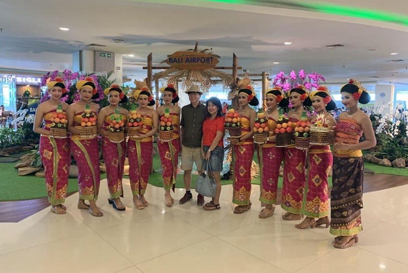 Wisatawan mancanegara berfoto dengan model berpakaian tradisional Bali di Terminal Bandara Internasional Ngurah Rai, Denpasar, Bali. 