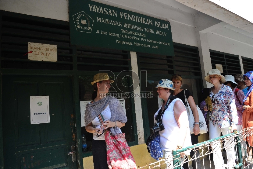 Wisatawan mancanegara berjalan saat mengunjungi Madrasah Nurul Iman di Penjaringan, Jakarta Utara, Rabu (13/5).