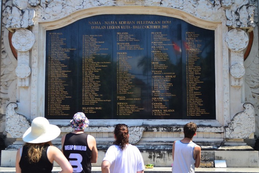 Wisatawan mancanegara membaca nama-nama korban bom pada Monumen Bom Bali, di Legian, Kuta, Bali, Kamis (8/10). Jelang peringatan 13 tahun peristiwa bom Bali pada 12 Oktober 2002, monumen yang dibangun untuk mengenang para korban ledakan bom tersebut ramai 