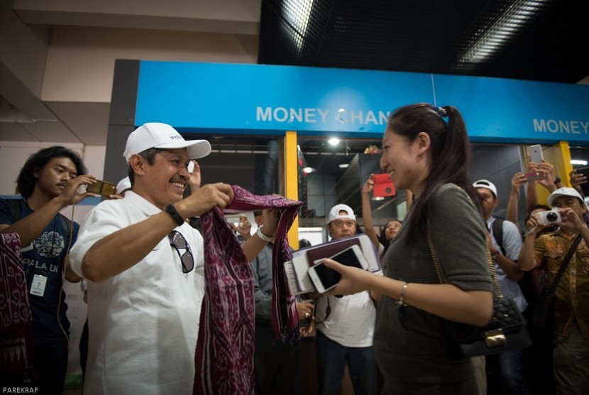 Wisatawan Mancanegara mendapat kalungan kain Tenun khas Ende di Terminal 2F Bandara Internasional Soekarno-Hatta, dalam perayaan Hari Pariwisata Dunia 2015