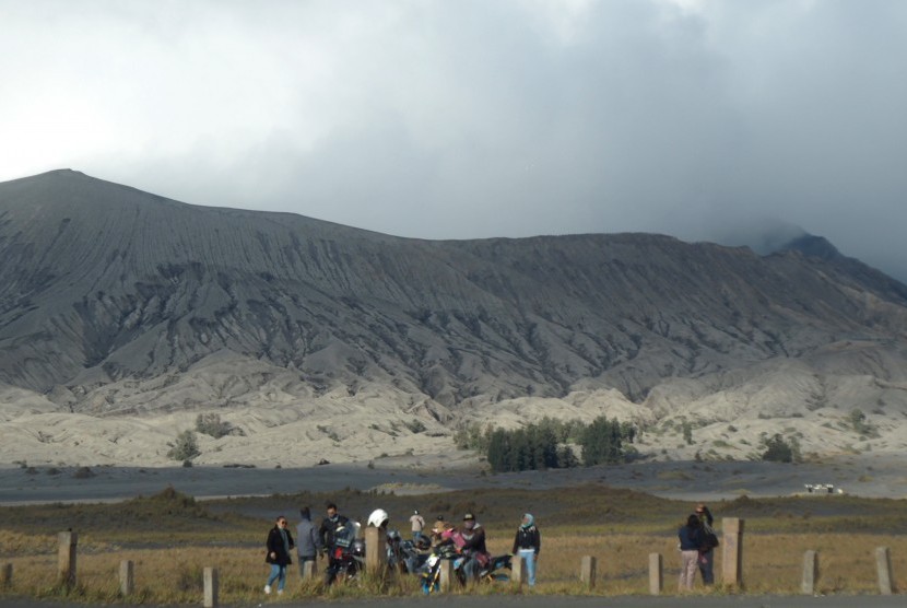 Kawasan Wisata Bromo Bebas Kendaraan Selama Sebulan. Wisatawan melihat pemandangan gunung Bromo yang mengalami erupsi dari kawasan lautan pasir di Probolinggo, Jawa Timur.