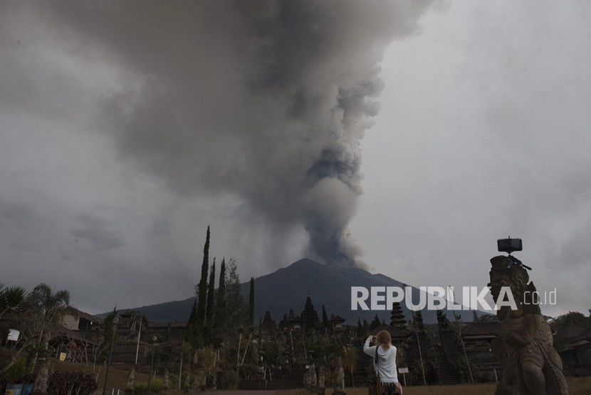 Wisatawan memotret Gunung Agung meletus di Pura Besakih, Karangasem, Bali, Selasa (28/11). 