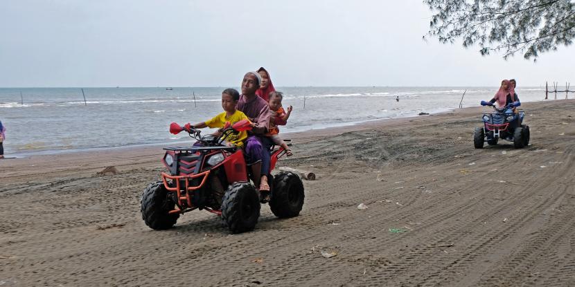 Wisatawan menaiki ATV ( All Terrain Vehicle) di Pantai Jodo di desa Sidorejo, Gringsing, Batang, Jawa Tengah, Ahad (23/1/2022). Pantai Jodo milik Akademi Militer Magelang yang digunakan untuk latihan militer tersebut menjadi destinasi wisata unggulan di kabupaten Batang