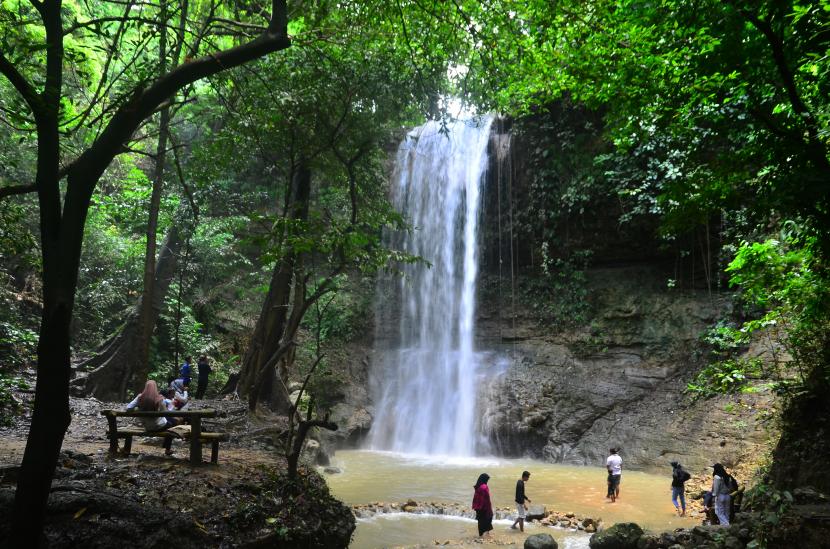 Wisatawan mengunjungi objek wisata air terjun Widuri di Dusun Widuri, Tawangharjo, Grobogan, Jawa Tengah, Minggu (14/3/2021). Wisata air terjun dengan ketinggian kurang lebih 40 meter yang terletak di pegunungan Kendeng itu menawarkan keindahan alam yang masih asri