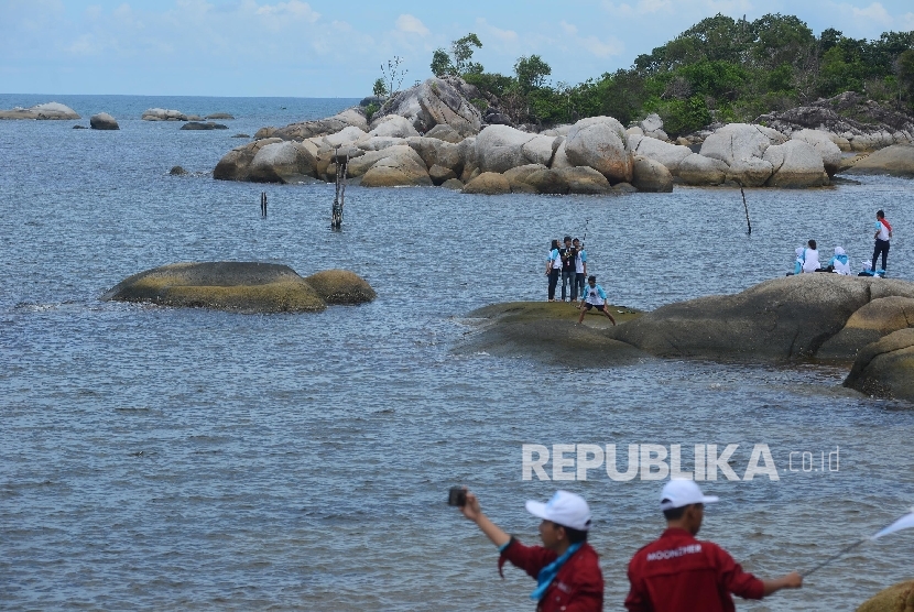 Wisatawan menikmati keindahan di Pantai Tanjung Tinggi, Belitung, Kamis (10/3).   (Republika/Raisan Al Farisi)