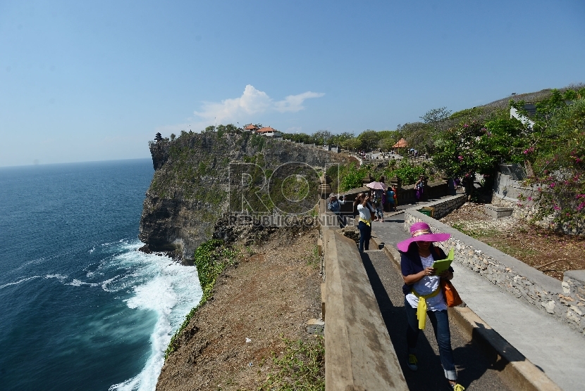  Wisatawan menikmati pemandangan pantai Uluwatu yang terletak di Uluwatu, Bali, Jumat (20/11). 