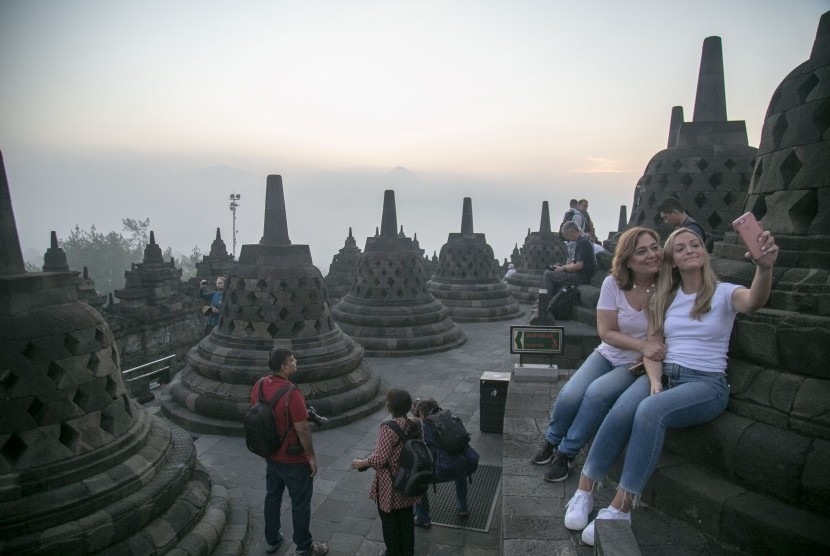 Wisatawan menikmati suasana matahari terbit di kawasan Taman Wisata Candi (TWC) Borobudur, Magelang, Jawa Tengah, Sabtu (18/5/2019).