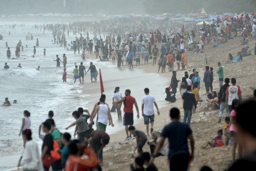 Tourists enjoy holiday season by flocking to Kuta beach, Badung, Bali, on December 31, 2017.