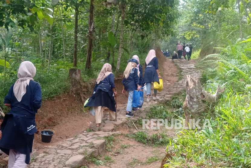 Wisatawan saba budaya Badui tengah berjalan kaki melintasi jalan setapak dengan topografi perbukitan di Kabupaten Lebak, Banten.