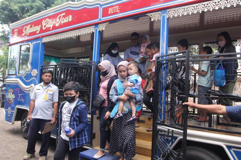 Wisatawan turun dari bus wisata Malang City Tour (Macito) di Malang, Jawa Timur, Selasa (5/7/2022). Pemerintah setempat berupaya menarik kunjungan wisatawan dengan menyediakan fasilitas bus wisata gratis dengan lima kali perjalanan keliling Kota Malang setiap harinya. 