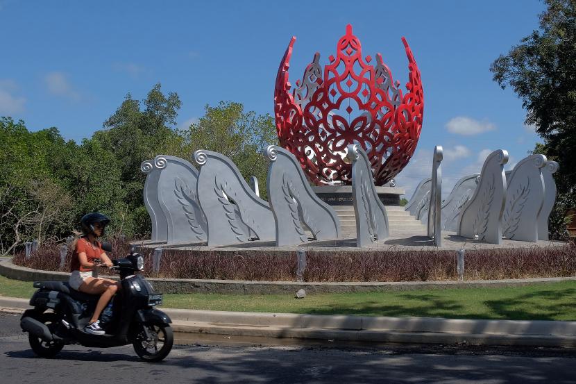 Wisatawan yang mengendarai sepeda motor melintas di dekat monumen G20 yang baru dibangun di Denpasar, Bali, Jumat (2/9/2022). Pembangunan monumen tersebut untuk menyambut Presidensi G20 Indonesia 2022 di Bali yang mengusung tema Recover Together, Recover Stronger.