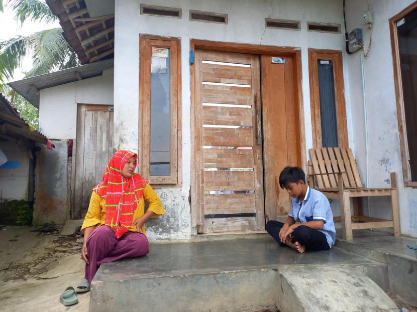 Wiwin (30 tahun), bersama anaknya, Irsyad (13), di rumahnya, Kampung Hergamanah, Desa Ciawang, Kecamatan Leuwisari, Kabupaten Tasikmalaya, Senin (9/1/2023). Irsyad merupakan salah satu korban keracunan ciki ngebul di Kabupaten Tasikmalaya beberapa waktu lalu.