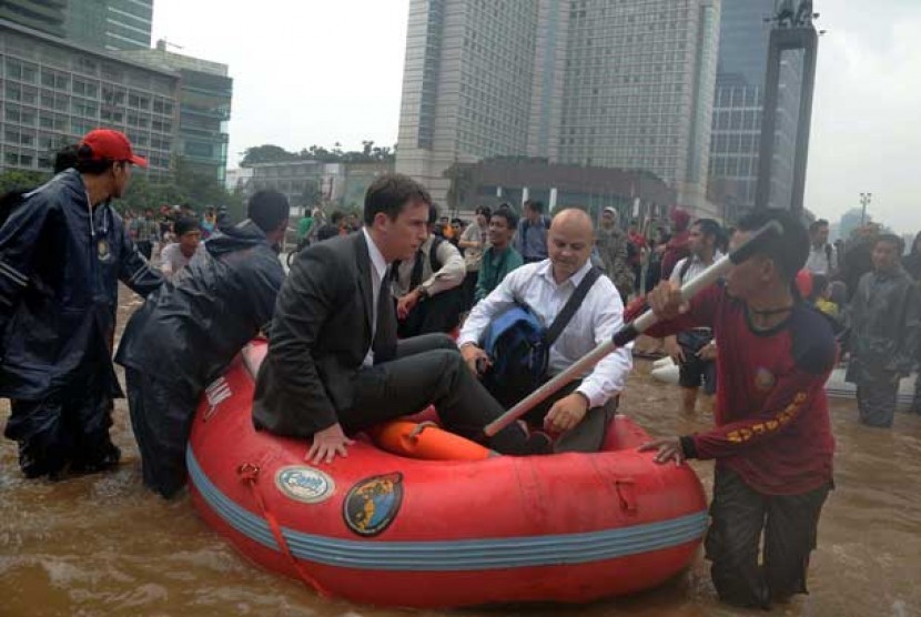 WNA dievakuasi naik perahu karet saat banjir di Bundaran HI, Jakarta, Kamis (17/1). 