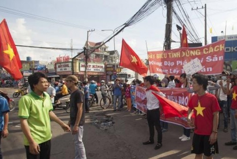 Workers wave Vietnamese national flags during a protest at an industrial zone in Binh Duong province May 14, 2014.
