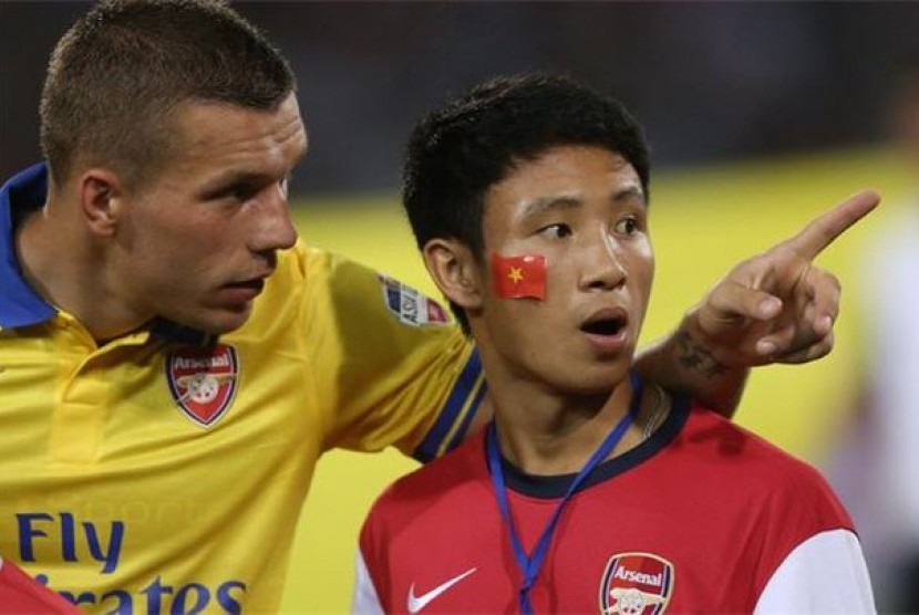 Xuan Tien (kanan) bersama striker Arsenal, Lukas Podolski, dalam sebuah pertandingan. 