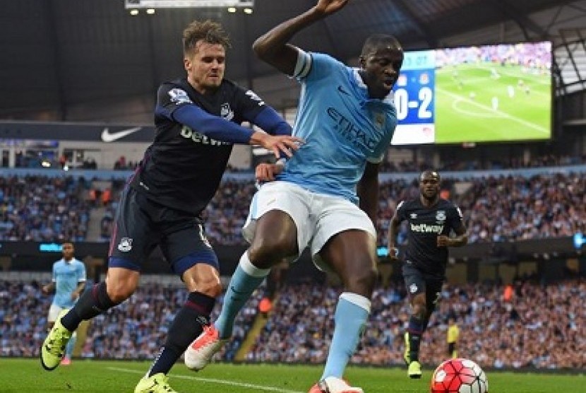 Yaya Toure berebut bola dengan pemain West Ham dalam lanjutan liga primer, Ahad (20/9) dini hari WIB.