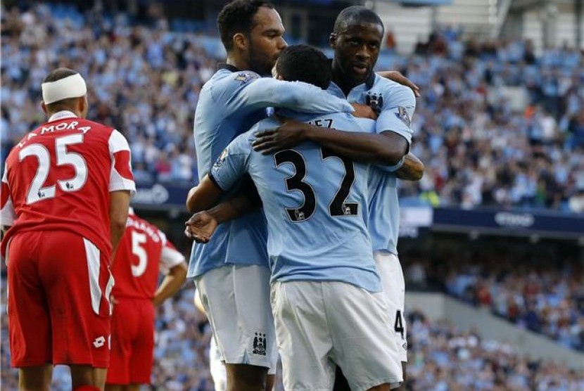 Yaya Toure (kanan), gelandang Manchester City, merayakan golnya saat menghadapi Queens Park Rangers di laga Liga Inggris di Stadion Etihad, Manchester, Sabtu (1/9). 