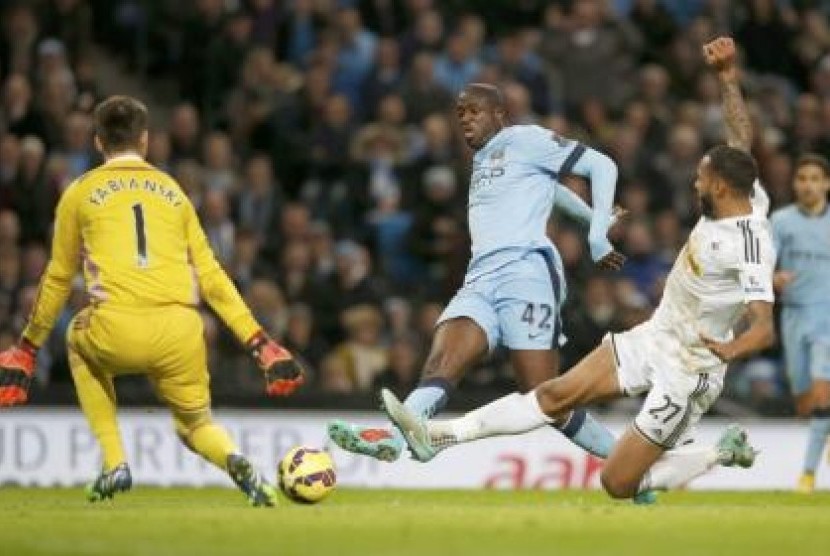 Yaya Toure saat mencetak gol ke gawang Swansea City, Sabtu (22/11).