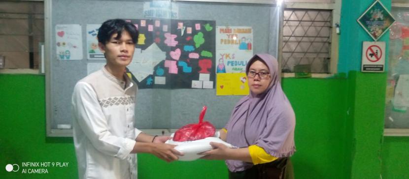 Yayasan Kesejahteraan Sosial (YKS) Parung Bingung menyerahkan bantuan beras dan daging kepada seorang anak yatim, dalam rangka Idul Fitri 1443, di Aula Gedung YKS 1 Parung Bingung, Sabtu (30/4).